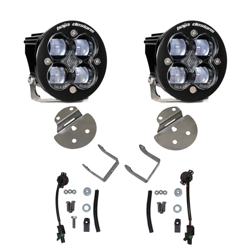 The Baja Designs 15-19 Canyon/Colorado Fog Light & Fog Pocket Kit includes a pair of black off-road LED fog lights, each equipped with four bulbs and mounted on metal brackets. The set also comes with additional mounting brackets, screws, washers, electrical connectors, and wiring. The Baja Designs brand name is prominently displayed on the top of each light housing.