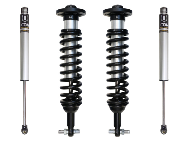 Image of four automotive shock absorbers. Two in the middle are coilover shocks with black springs, and the outer two are monotube shocks. All four have a sleek silver and black color scheme and are part of the ICON 2015+ Ford F-150 4WD 0-2.63in Stage 1 Suspension System from ICON.