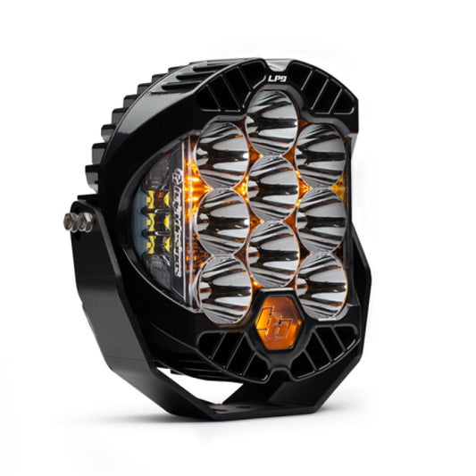 The Baja Designs LP9 Racer Edition Series High Speed Spot Pattern LED Light Pods in Clear is a product by Baja Designs. It is a black and silver LED light with multiple circular reflectors arranged in a grid pattern, some of which emit a warm amber glow. The light pods are mounted on a sturdy black bracket known for their rugged durability.