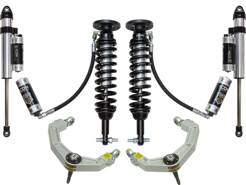 The ICON 2015+ Ford F-150 4WD 2-2.63in Stage 5 Suspension System w/Billet Uca includes two shock absorbers with attached reservoirs, two large coil springs, and two upper control arms. The components are symmetrically aligned and primarily black and silver, featuring some brand labeling.