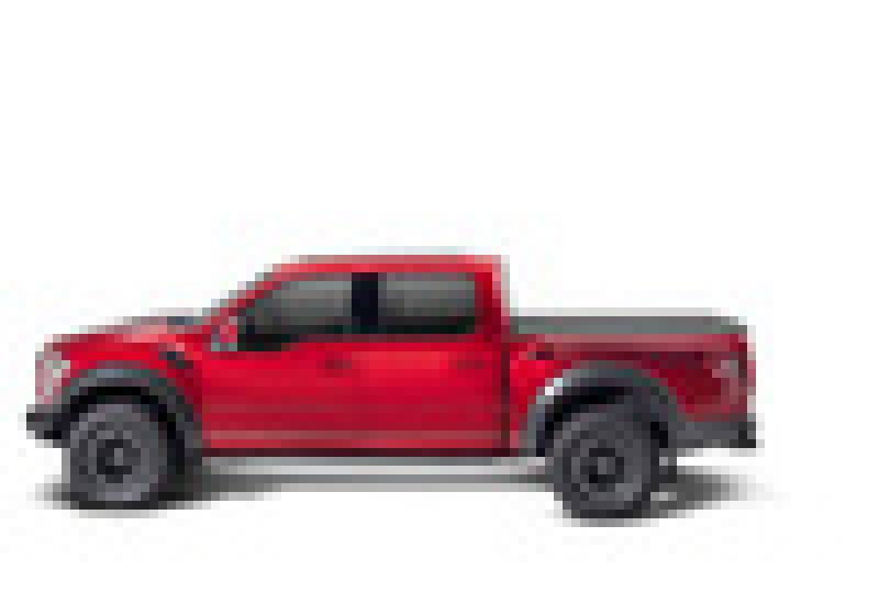 A red Chevrolet Silverado pickup truck, equipped with black accents and large off-road tires, is showcased against a white background. The side view highlights the four-door cabin with tinted windows and a robust 8ft bed, featuring the BAK 88-13 Chevy Silverado/GM Sierra Revolver X4s Bed Cover designed for 2014 HD /2500 /3500 models—perfect for any adventure.