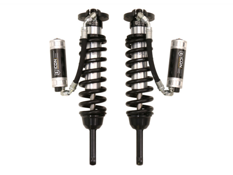 Two black and silver automotive shock absorbers with coiled springs are displayed vertically against a white background. Each rear shock absorber is equipped with an attached reservoir labeled "ICON." The design appears sturdy and engineered for high performance, ideal for 2010+ Toyota FJ Cruisers or 4Runners. This particular model is the ICON 2010+ Toyota FJ/4Runner Ext Travel 2.5 Series VS RR CDCV Coilover Kit w/700lb Spring Rate.