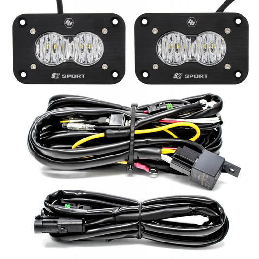 Displayed above a neatly coiled set of wiring and connectors are two black rectangular flush mount LED work light pods with visible bulbs. These lights, labeled "S2 Sport," are from the Baja Designs S2 Sport Flush Mount Wide Cornering Pattern LED Work Light Clear Lens Kit.