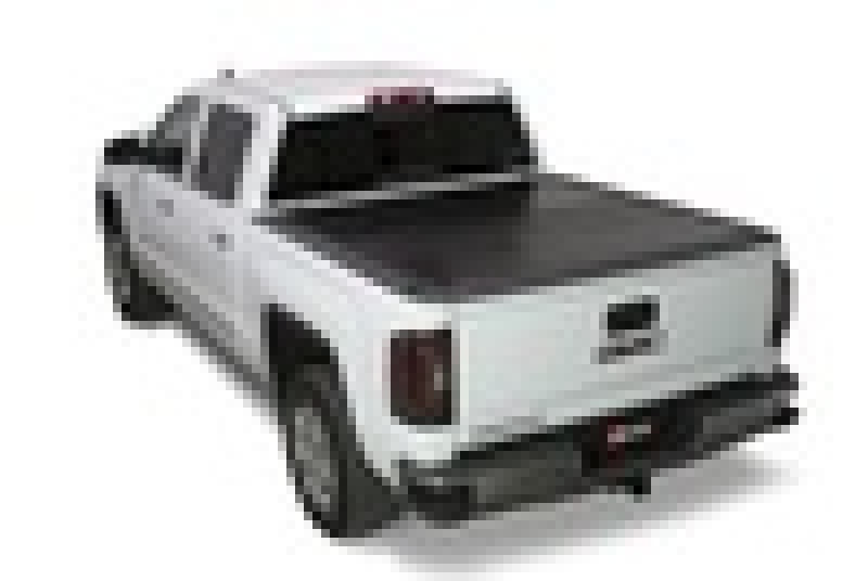 A white GMC Sierra pickup truck featuring a covered Fleetside Bed with the BAK BAKFlip G2 for 88-13 Chevy Silverado & C/K 1500 / 88-14 Chevy Silverado 2500/3500 HD models. The truck is viewed from the rear three-quarter angle, highlighting its tailgate and rear lights.