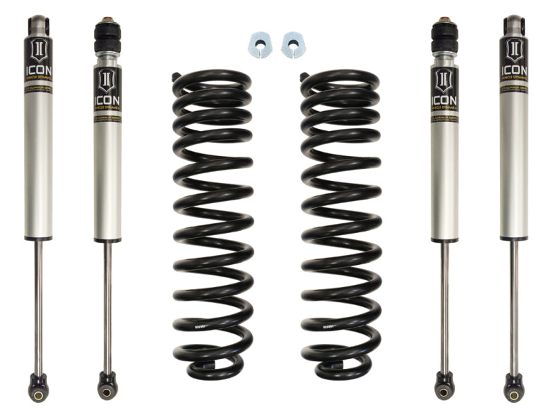 A symmetrical arrangement featuring the ICON 05-16 Ford F-250/F-350 2.5in Stage 1 Suspension System is laid out on a white background. This includes four cylindrical ICON rear shocks with connecting hardware at each end, two coiled springs, two small additional components, and a 4" block for an F250.