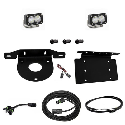 The Baja Designs 2021+ Ford Bronco Dual S1 Sport W/C Reverse Kit w/Lic Plate w/Upfitter includes two S1 Sport LED light pods, mounting brackets, bolts, a wiring harness, and connectors. The components are arranged neatly against a white background, showcasing all the necessary parts for installation on your Ford Bronco.