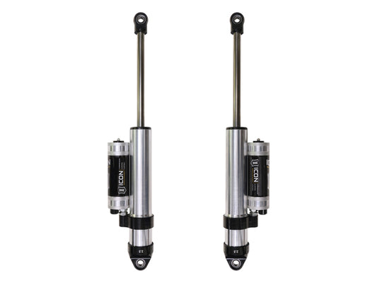 Two vertically aligned ICON 2019+ GM 1500 0-2in Rear 2.5 Series Shocks VS PB CDCV - Pair, featuring attached external reservoirs. These silver shocks with black accents prominently display the ICON logo on the reservoirs, making them perfect for off-road performance and designed specifically for automotive suspension systems.