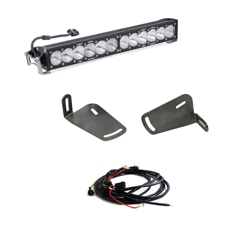 The image highlights a set of off-road vehicle lighting components. At the top, a Baja Designs OnX6+ 20in LED light bar featuring multiple bulbs is prominently displayed. In the middle, two mounting brackets designed for installation on a 2019+ Ram Rebel 1500 are shown. At the bottom, a wiring harness with connectors completes this comprehensive Baja Designs bumper kit.