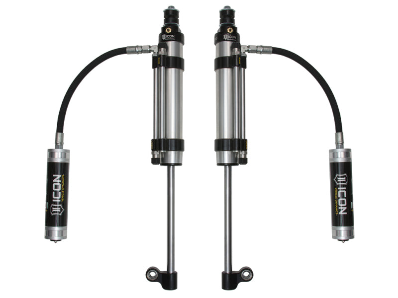 Two ICON 2007+ Toyota Tundra RXT Rear 2.5 Series Shocks Omega RR are shown, featuring external reservoirs connected by flexible hoses. The shocks are metallic with black accents and designed for off-road performance to enhance suspension. ICON branding is visible on the reservoirs, highlighting their adjustable valve technology.