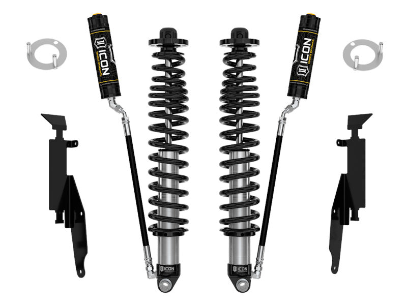 A set of ICON's 21-UP Ford Bronco 2-3in Rear 2.5 VS RR Coilover Kit, including adjustable coilover shocks and coil springs, complete with mounting brackets and hardware. The parts are precisely displayed on a white background, highlighting the shock absorbers' cylinders, springs, and the ICON logos on the shocks.