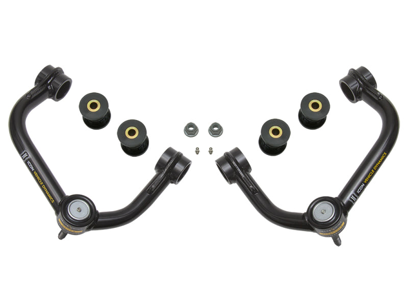 Two black, curved upper control arms with yellow accents and installed bushings from the ICON 04-20 Ford F-150 / 2014+ Ford Expedition Tubular Upper Control Arm Delta Joint Kit by ICON are positioned symmetrically on a white background. Four additional bushings and two nuts with washers are placed between the control arms, highlighting the ball joint connections for improved flexibility.