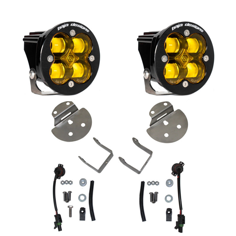 The Baja Designs 15-19 Canyon/Colorado Fog Light & Fog Pocket Kit - Amber includes two LED off-road lights with amber lenses, complete with mounting brackets, assembly hardware, and wiring harnesses. Each light has a round black housing with four LED bulbs. The comprehensive fog light kit conveniently arranges all accessories around the lights.