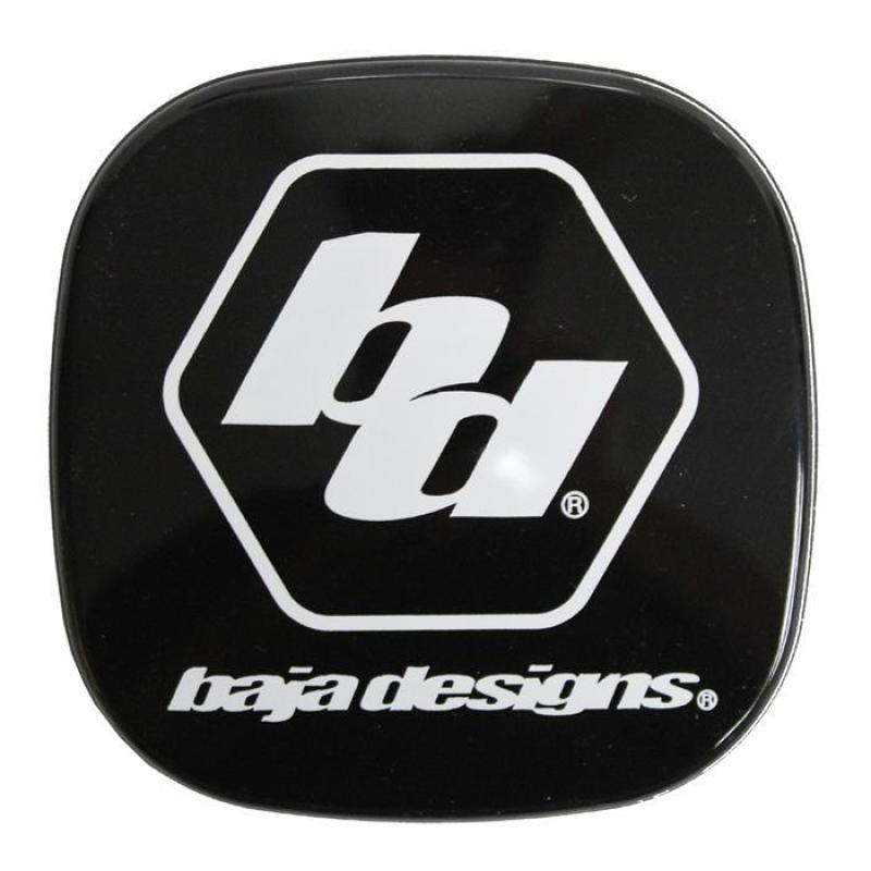 The product is a black square with rounded corners, showcasing a white hexagonal logo with the lowercase letters "bd" inside. Beneath the hexagon, the brand name "Baja Designs" is displayed in lowercase white text, making it an ideal component for your Baja Designs XL Rock Guard setup.