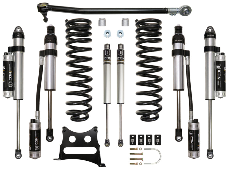 An array of off-road performance suspension components are laid out, including the ICON 2017+ Ford F-250/F-350 2.5in Stage 5 Suspension System from ICON, featuring items such as shock absorbers, coil springs, mounting brackets, and various bolts and hardware. The shock absorbers are silver and black with cylindrical reservoirs attached.