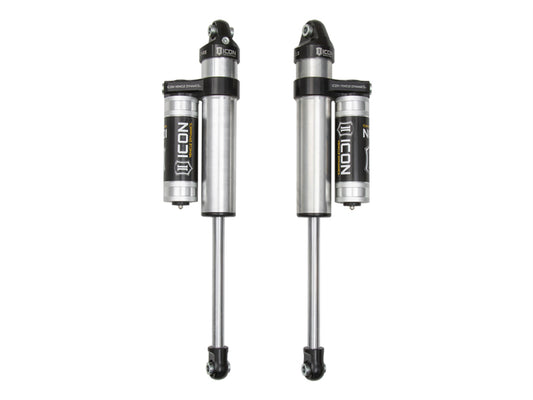 Two silver ICON 2019+ Ford Ranger Rear 2.5 Series Shocks VS PB with remote reservoirs are designed for off-road performance suspension systems. Displayed against a white background, both shocks feature the Icon logo and branding in black on the reservoirs and main body, and they are 100% rebuildable for enhanced durability.