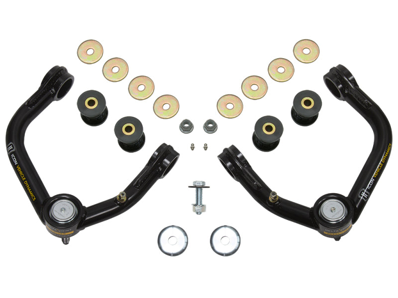 The image displays the ICON 96-04 Toyota Tacoma/96-02 Toyota 4Runner Tubular Upper Control Arm Delta Joint Kit by ICON, featuring two black upper control arms equipped with bushings and Delta Joints, multiple washers, small bolts, and black cylindrical spacers arranged symmetrically on a white background.