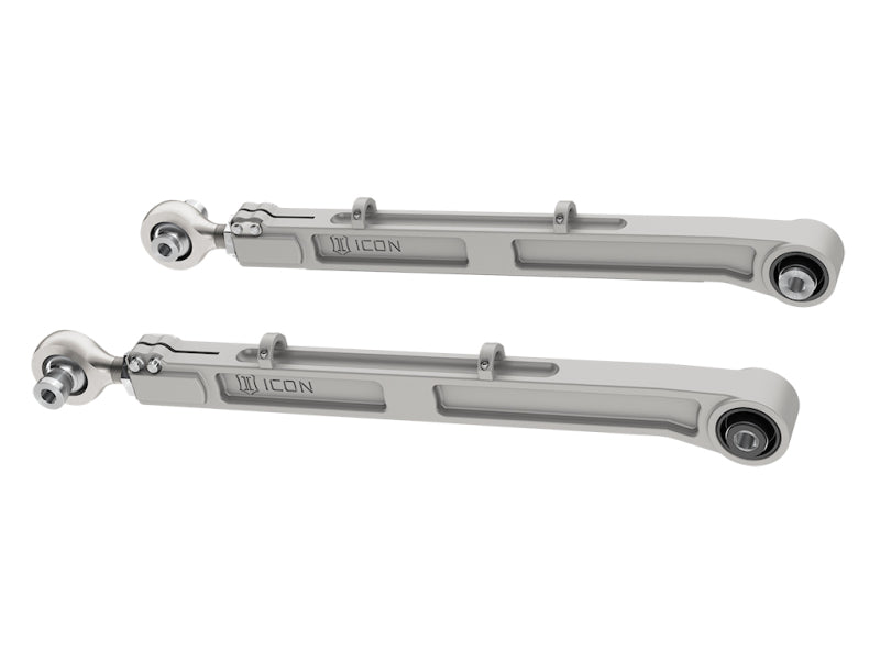 The ICON 2021+ Ford Bronco Billet Rear Lower Link Kit displays two robust grey link arms, prominently branded with "ICON," against a white background. Made from durable 6061 aluminum, these arms feature pivot points and mounting brackets at either end, specifically designed for the Ford Bronco.