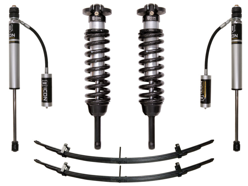 Complete ICON 05-15 Toyota Tacoma 0-3.5in / 2016+ Toyota Tacoma 0-2.75in Stage 2 Suspension System, featuring two coilover shocks with remote reservoirs, two struts, and two leaf springs arranged on a white background. The components are primarily black with some metallic details.