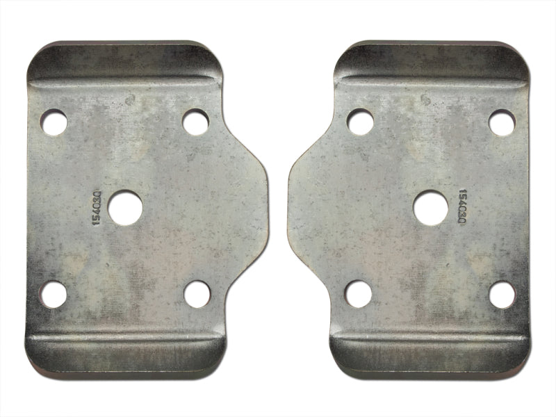 Two ICON rectangular metal brackets facing each other with symmetrical cutouts and four holes on each, designed for a 2005+ Toyota Tacoma. They appear slightly curved at the top and bottom edges, with a worn, grayish finish. Each bracket has indented markings or codes on the surface. This is the ICON 2005+ Toyota Tacoma Rear Striker Kit for U-Bolt Flip.