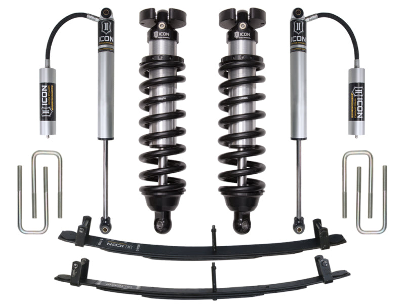 A set of ICON 95.5-04 Toyota Tacoma 0-3in Stage 2 Suspension System components displayed on a white background, featuring ICON Vehicle Dynamics coilover shocks with independent reservoirs, leaf springs, and U-bolts. The components are branded with "ICON" logos and organized neatly in a symmetrical arrangement.